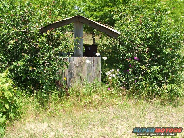 Wooden structure with a roof in a yard setting
