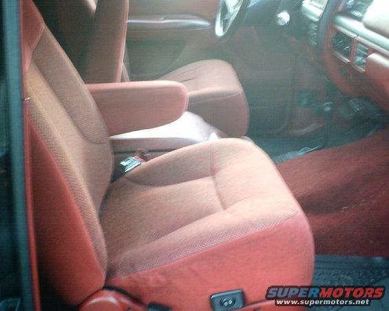 Front seats and dashboard of a vehicle with red upholstery