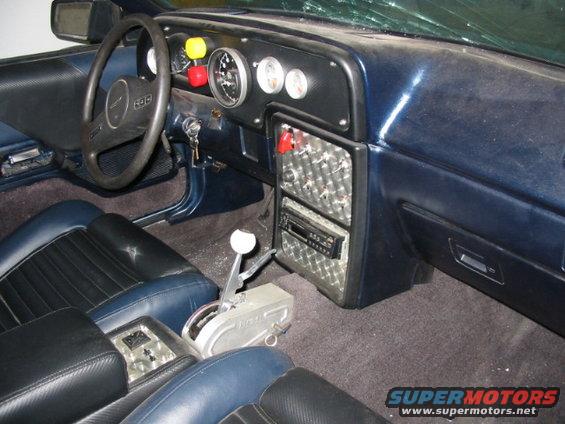 1987 Ford Thunderbird interior with blue and black seats, aftermarket shifter, and custom dashboard gauges