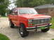 1985 Ford Bronco - This red 1985 Ford Bronco features a distinctive chrome grille and a John Deere license plate holder.