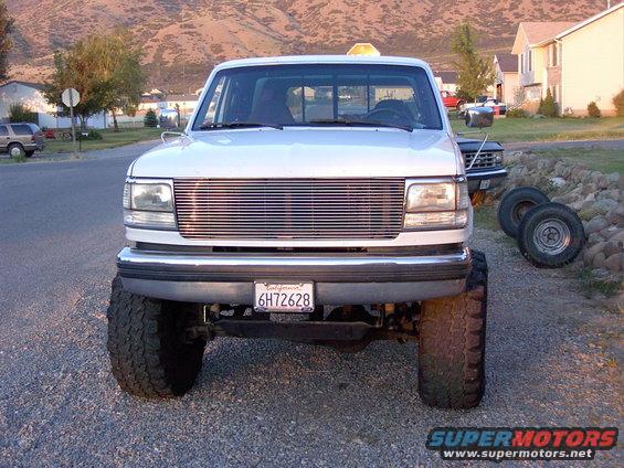 Front view of a white 1992 Ford F-150 with a chrome grille and large tires