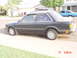 1992 Ford F-150 - This dark sedan, identified by its body style as a 1992 model, is parked curbside with another vehicle visible in the background.