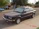 1992 Ford F-150 - A dark-colored BMW E30 coupe is parked on a residential street, with a white SUV visible in the background.