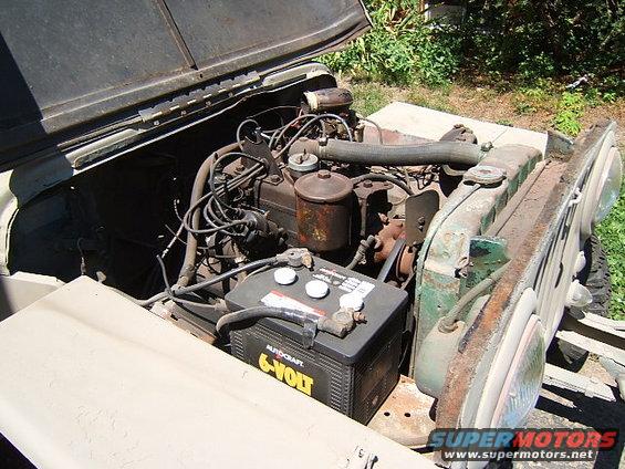 Jeep engine bay with 6-volt battery, radiator, and engine components visible