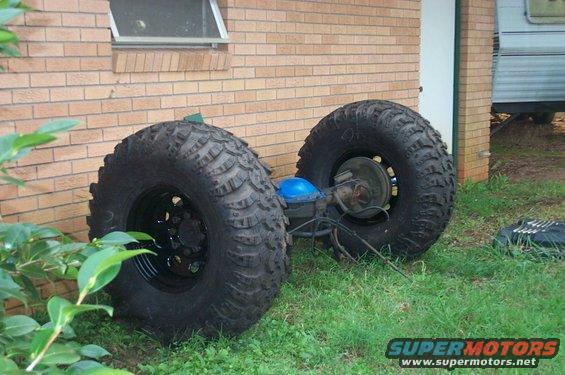 Rear axle with large off-road tires and blue differential cover