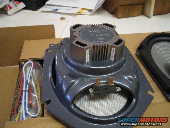 Infinity car speaker with wiring harness and another speaker part in the background
