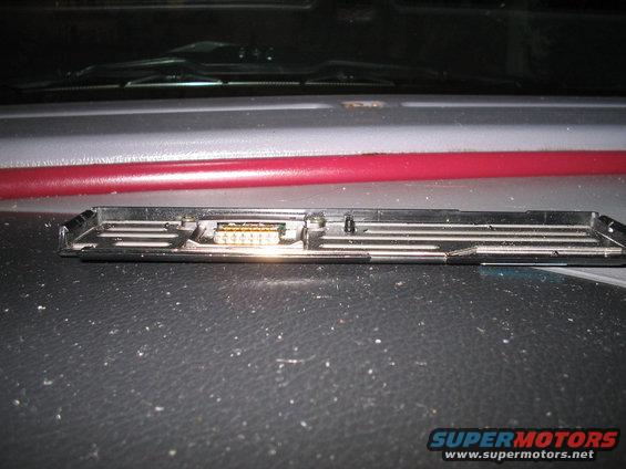 Close-up of a black plastic car interior part with a multi-pin connector