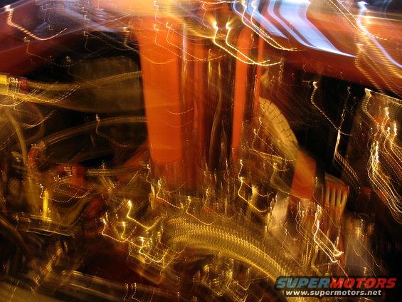 Engine bay with orange components and blurred yellow lights