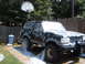 1988 Ford Bronco - A black Ford Bronco is prepped for painting, covered in primer and plastic sheeting.