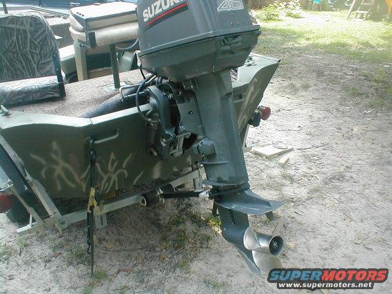 Green boat with camouflage seat and Suzuki 40 outboard motor on a trailer