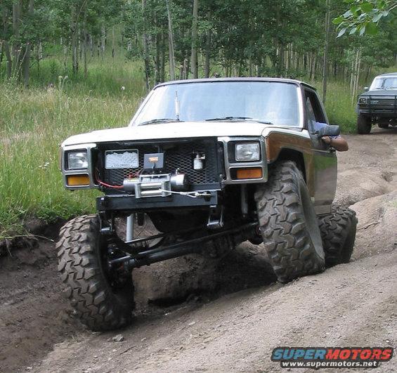 White and wood-paneled off-road SUV with winch, front 3/4 view