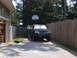 1988 Ford Bronco - A dark green SUV sits in a driveway with its doors open, a basketball hoop visible in the background.
