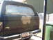 1988 Ford Bronco - The rear of a vehicle is shown with the window covered in plastic and tape, likely in preparation for painting.