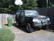 1988 Ford Bronco - A camouflaged Ford Bronco sits in a driveway next to a trash can and a basketball hoop.