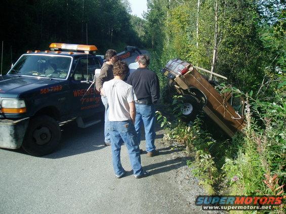 just about out, except the wrecker wa out of room to pull, so we hooked up my dad's truck w/ a chain to hold her in place, while the wrecker repositioned