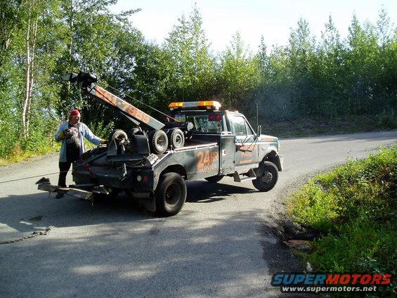 wrecker almost lifting a tire, it was off the ground earlier, but he lowered the boom and set it back down