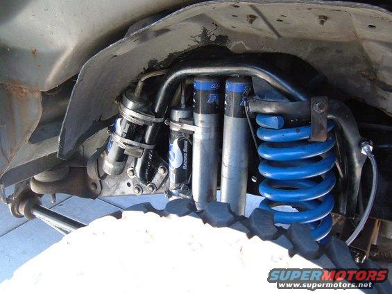 Close-up of front suspension with dual Fox Racing Shox and blue coil springs