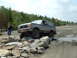 1995 Ford Bronco - A Ford Bronco navigates a rocky obstacle course on a dirt road.