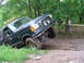 1979 Ford Bronco - Modified SUV tackling challenging off-road terrain with one wheel elevated.