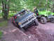 1979 Ford Bronco - Two off-road vehicles navigate a challenging dirt trail with one vehicle stuck in a deep rut.