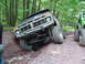 1979 Ford Bronco - This 1979 Ford Bronco navigates a challenging off-road course, with a green Jeep visible in the background.