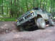 1979 Ford Bronco - A modified 1978 Ford Bronco navigates a challenging off-road trail in a wooded area.