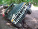 1979 Ford Bronco - A dark green 1978 Ford Bronco is stuck in a ditch while off-roading, with another vehicle visible in the background.