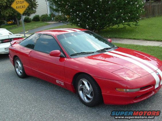 Red 1996 Ford Probe with white racing stripes and 'GTS' badge