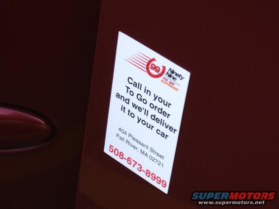 Sticker on car door advertises 'Ninety Nine To Go Express' delivery service with phone number 508-673-8999