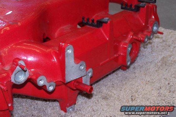 Red engine intake manifold with silver mounting brackets and small red tubes