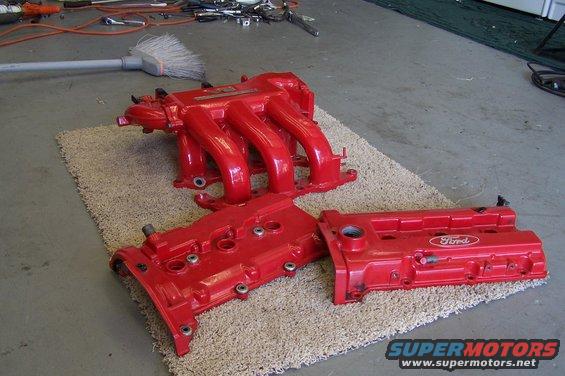 Red Ford intake manifold and valve covers on a rug