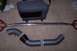 1997 Ford Probe - Car parts including a strut bar and intake piping laid out on a carpeted surface.