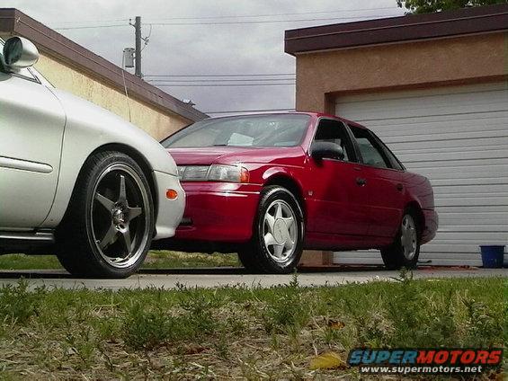 Red 1992 Ford Taurus parked next to a white car in a driveway