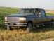 1996 Ford F-350 - This 1996 Ford F-350 pickup truck is parked in a field with green crops and dry grass.