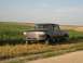 1996 Ford F-350 - Dark blue 1996 Ford F-350 crew cab pickup truck sits parked in a rural setting with fields on either side.