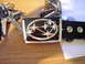 1990 Mitsubishi Eclipse - A Subaru belt buckle is shown with car keys and coins, resting on a wooden table.