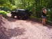 1995 Ford Bronco - Black 1995 Ford Bronco navigates an off-road trail with a person taking photos.