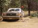 1995 Ford Bronco - A Ford Bronco navigates a muddy trail, its front tires submerged in water.