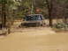 1995 Ford Bronco - An off-road vehicle is stuck deep in the mud, with only its front end visible above the brown water and dirt.