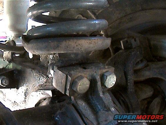 Close-up of a rusty truck suspension component with a coil spring