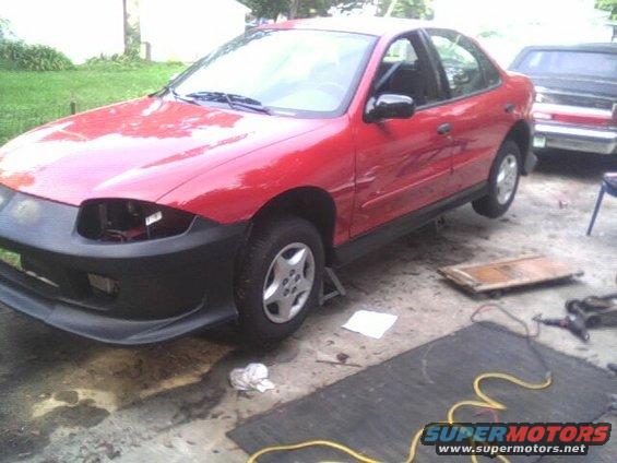 Red 2005 Chevrolet Cavalier sedan on jack stands with front bumper removed