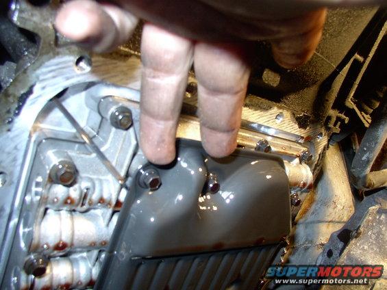 There's two of the filter bolts. Expect a second deluge of fluid when you remove the filter from the valve body. Your hair has been warned !