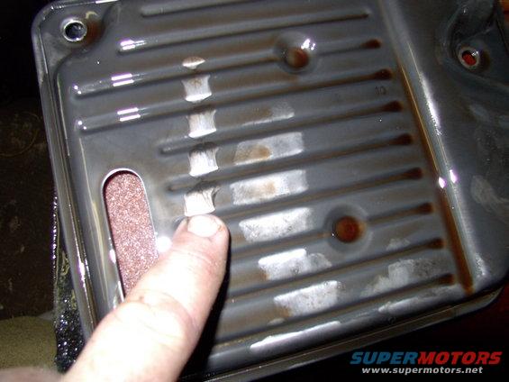 With the old filter out on the bench we can see the slight film built up on the filter housing and the dirty paper element through the slit to the left of my finger.