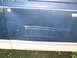 1987 Ford Bronco - Close-up of a damaged blue vehicle door with visible scratches and a dent.