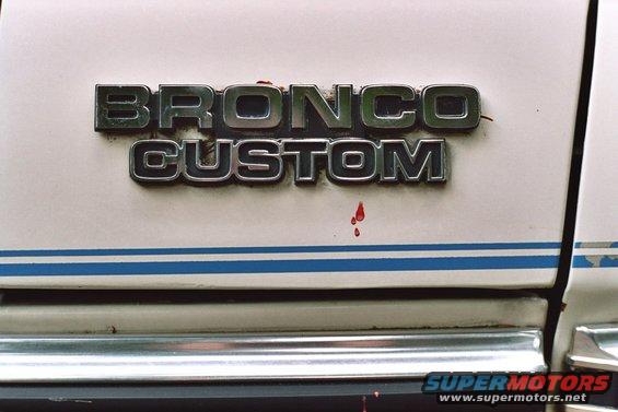 Bronco Custom emblem on white vehicle with blue stripe