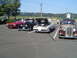 1964 Ford Fairlane - A white Pontiac Firebird is parked with its hood open, alongside other classic cars.