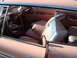 1964 Ford Fairlane - Interior view of a vintage car showing the seats, steering wheel, and dice hanging from the mirror.