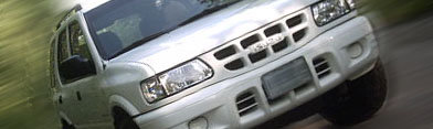 Silver 2000 Isuzu Rodeo SUV, front 3/4 view, slight motion blur, clear grille badge