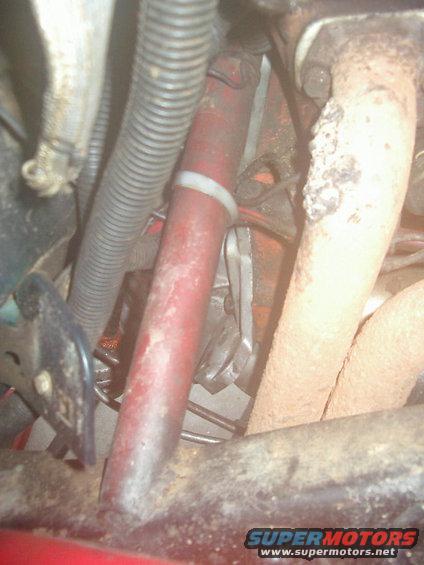 Close-up of engine parts including hoses and exhaust manifold