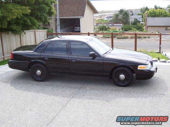 Black 2003 Ford Crown Victoria sedan parked on a driveway, side view
